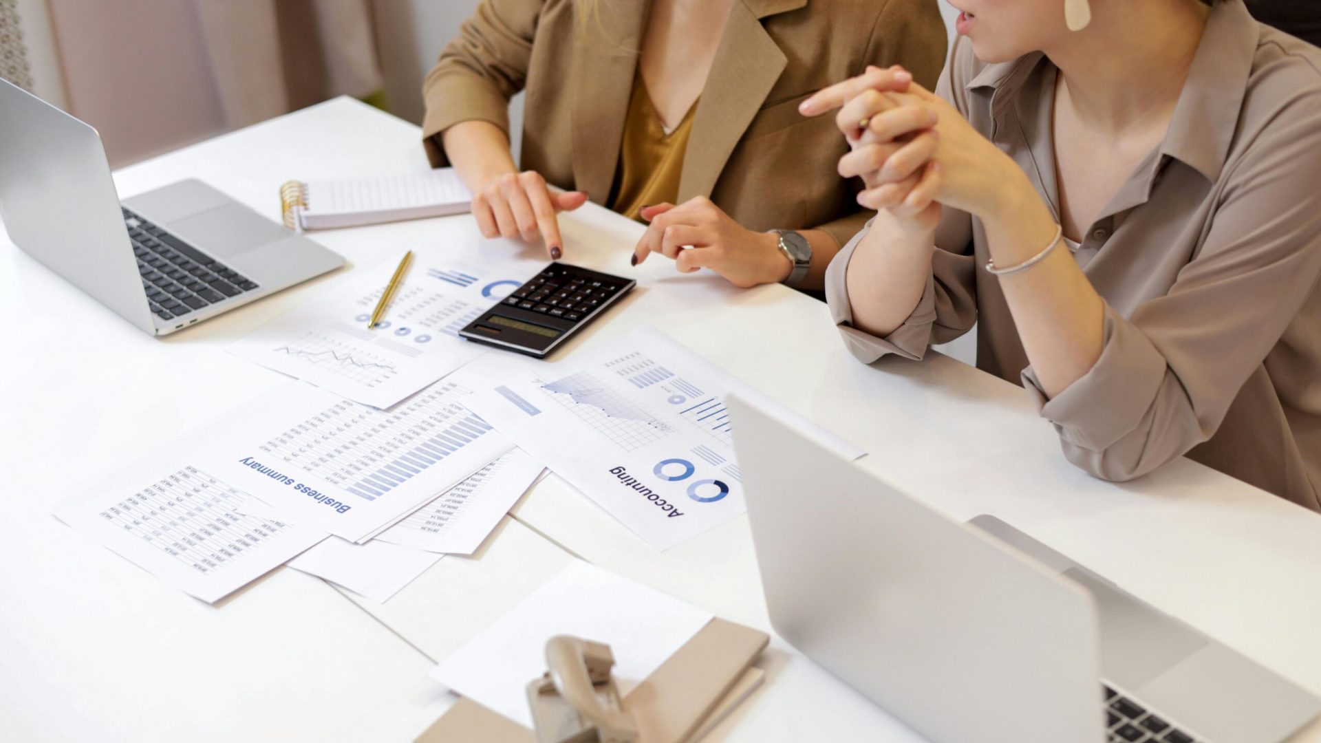 Two professionals collaborating on financial documents in a modern office setting.